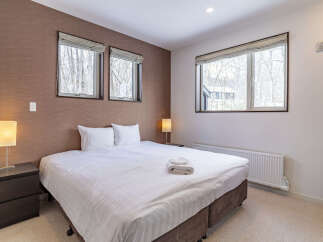 Experience comfort and style in this beautifully appointed bedroom, featuring a plush king-sized bed dressed in crisp white linens.
