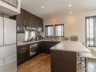Experience modern living in this sleek kitchen featuring dark wood cabinetry and a spacious white quartz countertop island.