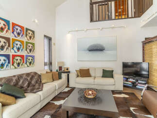 This spacious living room features a large, comfortable sectional sofa adorned with plush throw pillows and a cozy blanket, perfect for relaxation.