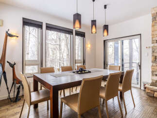 Experience elegant dining in this spacious room, featuring a large wooden table surrounded by comfortable leather chairs, perfect for hosting gatherings.