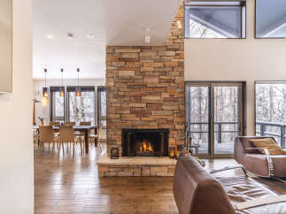 Experience cozy living in this spacious home featuring a stunning floor-to-ceiling stone fireplace, perfect for gathering on chilly evenings.