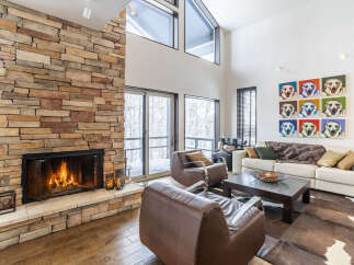 Experience luxury living in this stunning great room, featuring a soaring cathedral ceiling and a magnificent floor-to-ceiling stone fireplace.