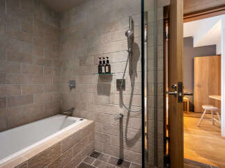 Experience modern comfort in this bathroom featuring a sleek bathtub and a separate glass-enclosed shower.