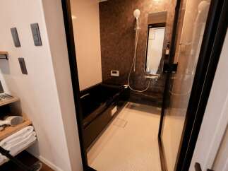 Experience modern comfort in this bathroom featuring a sleek, deep soaking tub and a separate glass-enclosed shower.