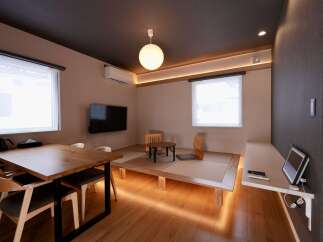 Experience modern Japanese living in this beautifully designed room, featuring a tatami mat area with low seating and a traditional low table.
