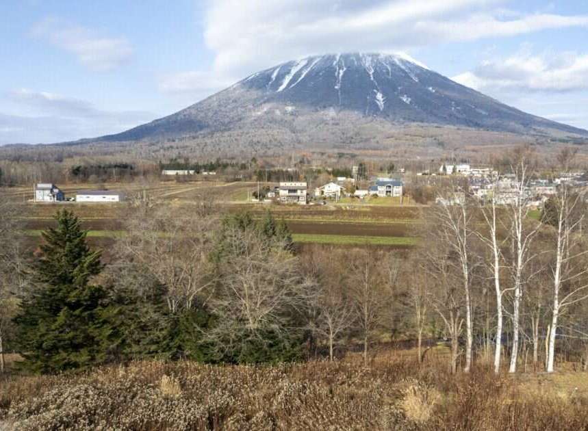 Discover your dream home nestled in a serene landscape with a majestic snow-capped mountain as your backdrop.