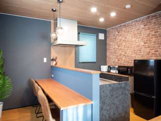 Discover this modern kitchen featuring a sleek range hood, elegant pendant lighting, and a stylish brick accent wall.