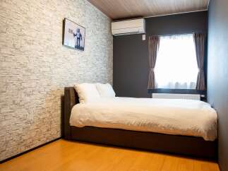 Experience comfort and style in this modern bedroom, featuring a cozy bed with crisp white linens and plush pillows.