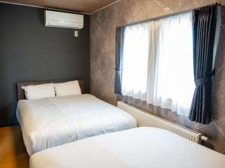 Experience comfort and style in this modern bedroom featuring two plush beds adorned with crisp white linens.