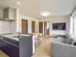 Experience modern living in this beautifully appointed apartment, featuring a sleek, integrated kitchen with a stylish range hood and ample counter space.
