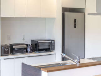 Discover a modern kitchen featuring sleek cabinetry and a full-sized Haier refrigerator.