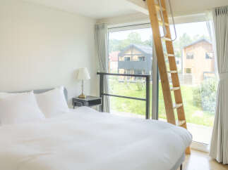 Experience comfort and style in this beautifully appointed bedroom, featuring a plush bed with crisp white linens and ample natural light.