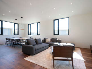 Experience modern living in this spacious open-concept home, featuring a sleek sectional sofa and a large dining area perfect for entertaining.