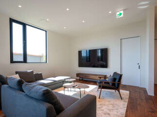 Experience modern living in this spacious living room, featuring a large sectional sofa perfect for relaxation and entertaining.