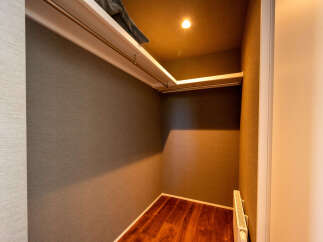 Discover ample storage in this walk-in closet, featuring a built-in shelf and a convenient clothing rod.