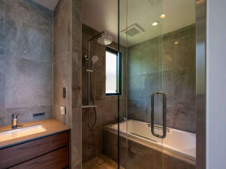 Experience modern luxury in this stunning bathroom, featuring a sleek vanity with a vessel sink and rich wood cabinetry.