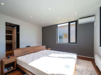 Experience modern comfort in this spacious bedroom featuring two twin mattresses on a sleek wooden bed frame.
