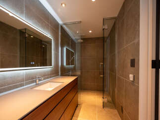 Experience modern luxury in this stunning bathroom featuring a sleek vanity with a built-in sink and ample storage.