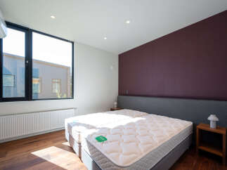 Experience modern comfort in this spacious bedroom featuring two plush mattresses for ultimate relaxation.