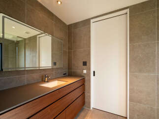Experience modern luxury in this stunning bathroom, featuring a sleek vanity with ample storage and a built-in sink.