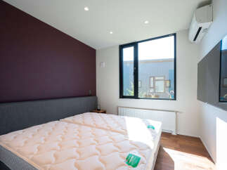 Experience modern comfort in this stylish bedroom featuring two plush mattresses for ultimate relaxation.