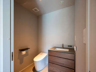 Discover modern comfort in this sleek bathroom, featuring a wall-mounted toilet and a stylish vanity with ample storage.