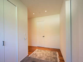 Step into this modern entryway featuring sleek white doors and warm hardwood floors.