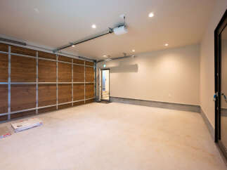 Discover this spacious garage featuring a beautiful wooden sectional garage door, perfect for any home.