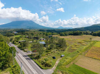 Discover serene living in this picturesque landscape, featuring modern homes nestled amidst lush greenery and rolling hills.