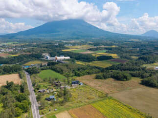 Discover this stunning rural landscape featuring a majestic mountain backdrop, perfect for those seeking tranquility and natural beauty.