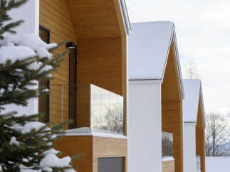 Experience modern living in this stunning property featuring a unique architectural design with warm wooden exteriors and sleek white accents.