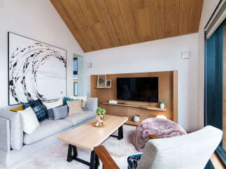 Experience modern living in this stylish living room, featuring a large abstract artwork and a comfortable grey sectional sofa adorned with decorative pillows.