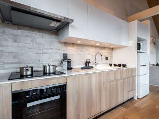 Discover this modern kitchen featuring sleek white cabinetry and warm wood accents.