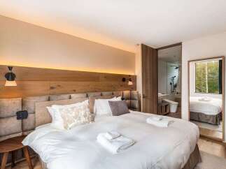 Experience modern luxury in this beautifully appointed bedroom, featuring a plush king-sized bed with crisp white linens and accent pillows.