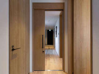 Step into a modern hallway featuring elegant wooden doors and a sleek sliding door.