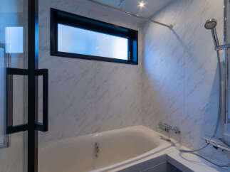Experience modern comfort in this bathroom featuring a sleek bathtub and a convenient showerhead.