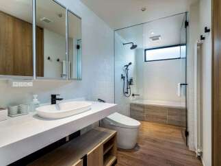 Experience modern luxury in this stunning bathroom featuring a sleek vanity with a vessel sink and a wall-mounted faucet.