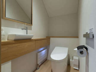 Experience modern comfort in this meticulously designed bathroom, featuring a sleek vessel sink atop a floating wooden vanity.