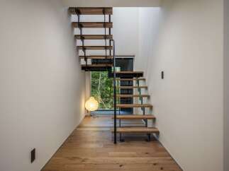 Experience modern living with this stunning staircase featuring floating wooden treads and a sleek black metal frame.