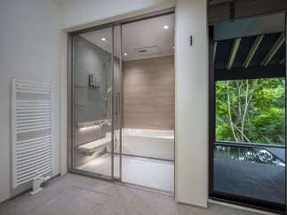 Experience modern luxury in this bathroom featuring a spacious glass-enclosed shower with a built-in bench and a sleek bathtub.