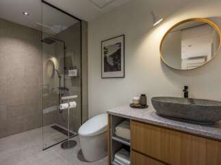 Experience modern luxury in this stunning bathroom featuring a spacious walk-in shower with elegant stone tiling.