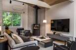 Experience modern living in this beautifully designed living room, featuring a sleek wood-burning stove as a focal point.