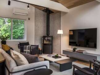 Experience modern living in this beautifully designed living room, featuring a sleek wood-burning stove as a focal point.