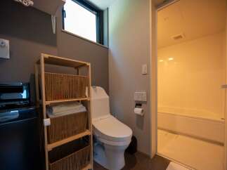 This modern bathroom features a sleek white toilet and a separate bathtub area, perfect for relaxation.