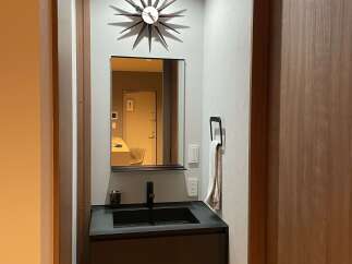Discover modern elegance in this compact bathroom featuring a sleek vanity with a black sink and faucet.