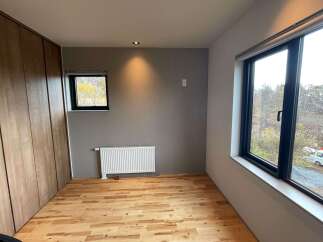 Discover this inviting room featuring a sleek wooden wardrobe and a modern white radiator.