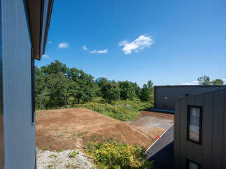 Discover modern living in this new construction property, featuring sleek, dark-paneled exteriors and large windows offering scenic views.