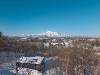 Experience the serene beauty of a winter wonderland with this stunning property offering panoramic views of snow-capped mountains.
