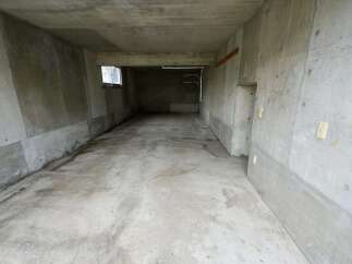 Discover this spacious concrete garage, perfect for secure vehicle storage or as a versatile workshop space.