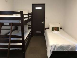 This cozy room features a dark wood bunk bed with white linens, perfect for accommodating multiple guests.
